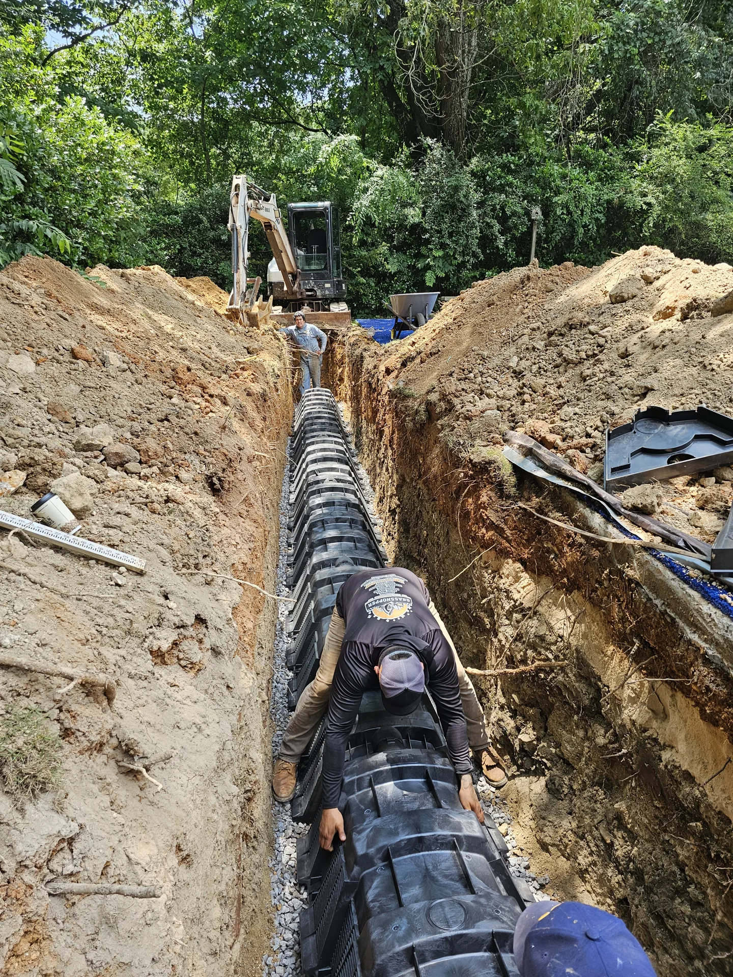 Crew placing underground chamber units in a prepared trench.