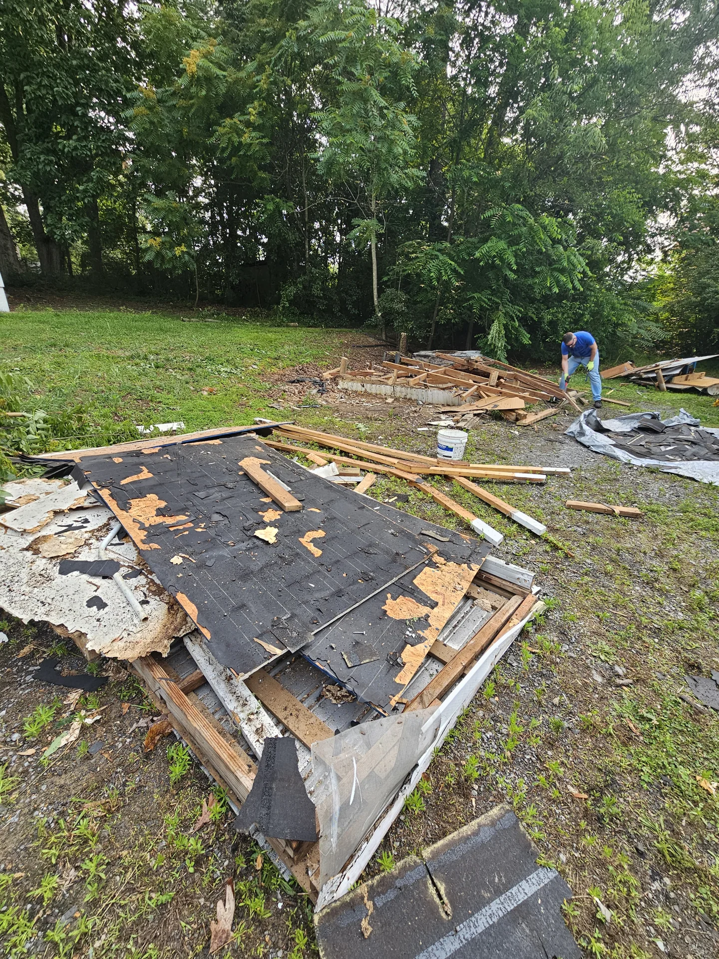 Dismantled wooden structure being cleared from the property.