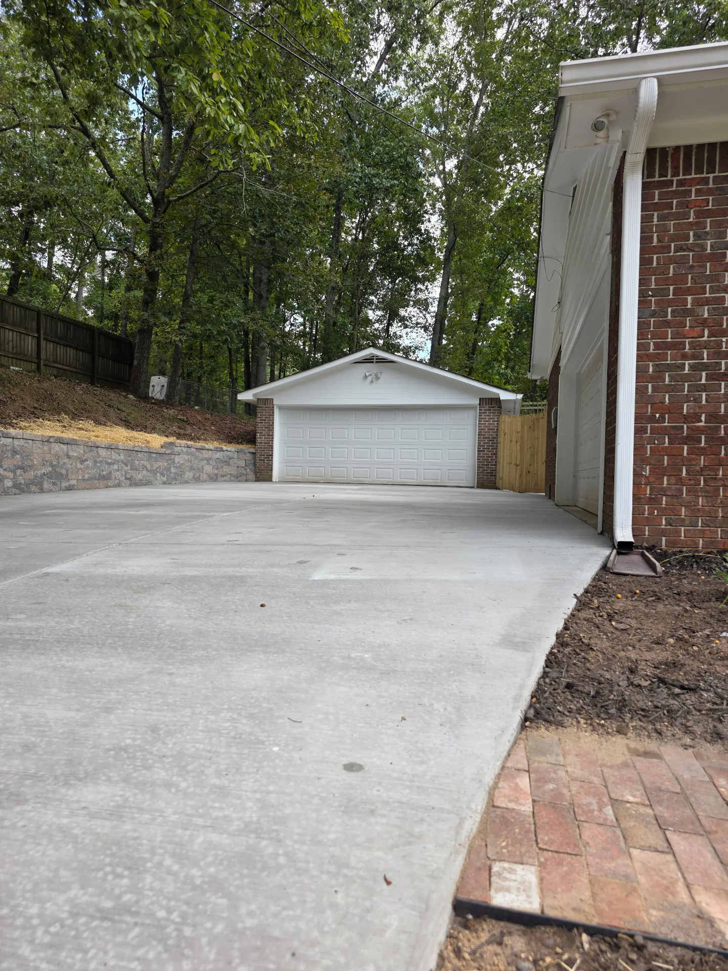 Completed concrete driveway beside the house and garage.